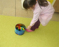 Una niña experimenta con una caja  de metal y un imán