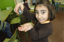 una niña experimenta la fuerza del imán con diversos objetos