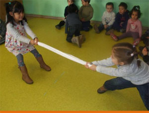 Dos niños experimentan tirando de una sábana por los extremos