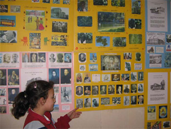 Una alumna de 4º de Primaria muestra el cartel en asturiano sobre Historia de la Filosofía. 